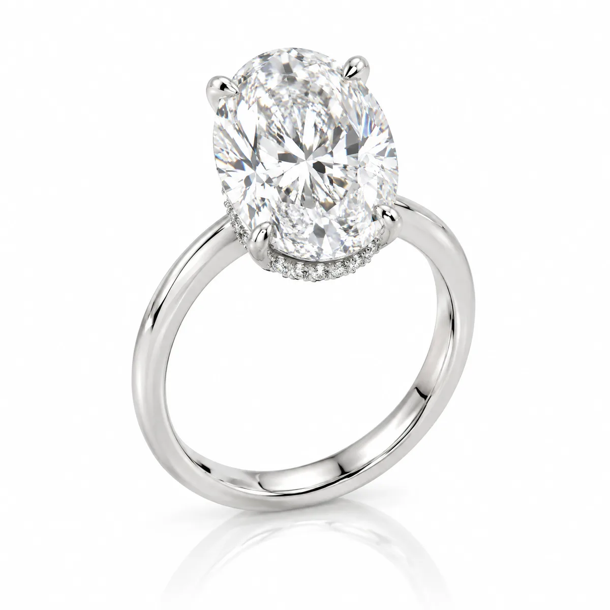 Oval hidden halo: Oval-cut diamond with a hidden halo beneath the stone, on a slim 18k white gold band